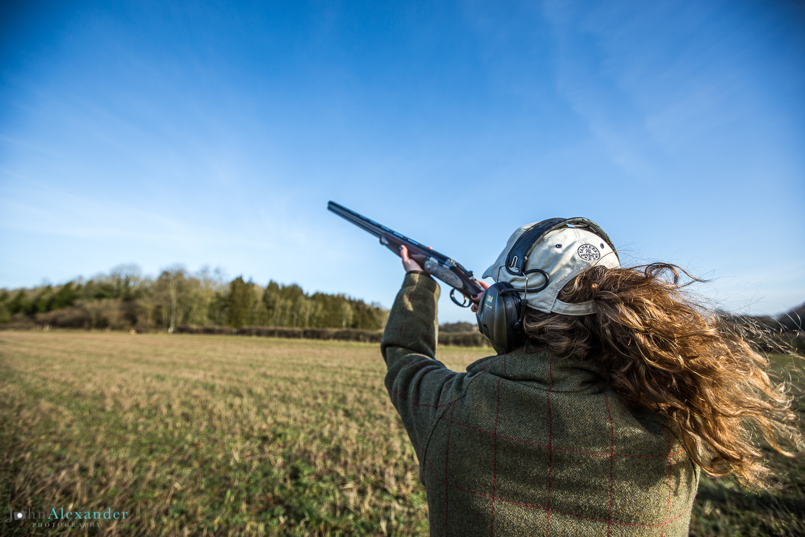 Young Lady Gun shooting pheasant in blue sky